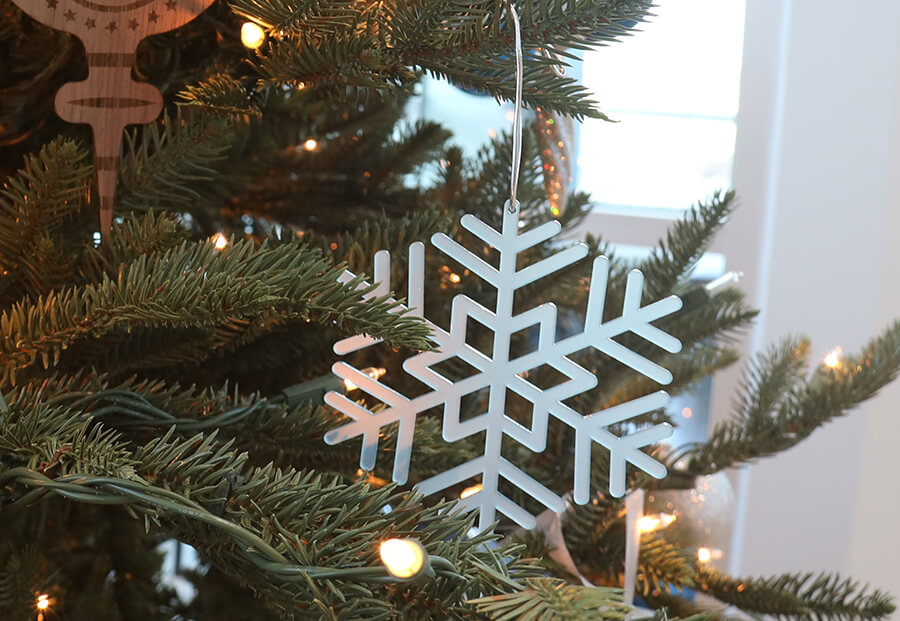 snowflake shaped ornament hung from the christmas tree