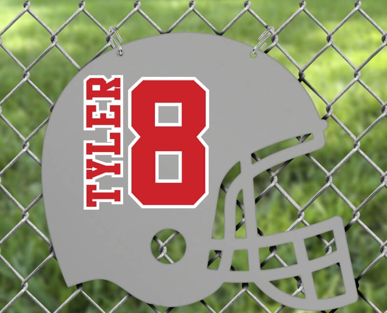 Gray football helmet decor hanging from a chain link fence, customized with name and player number