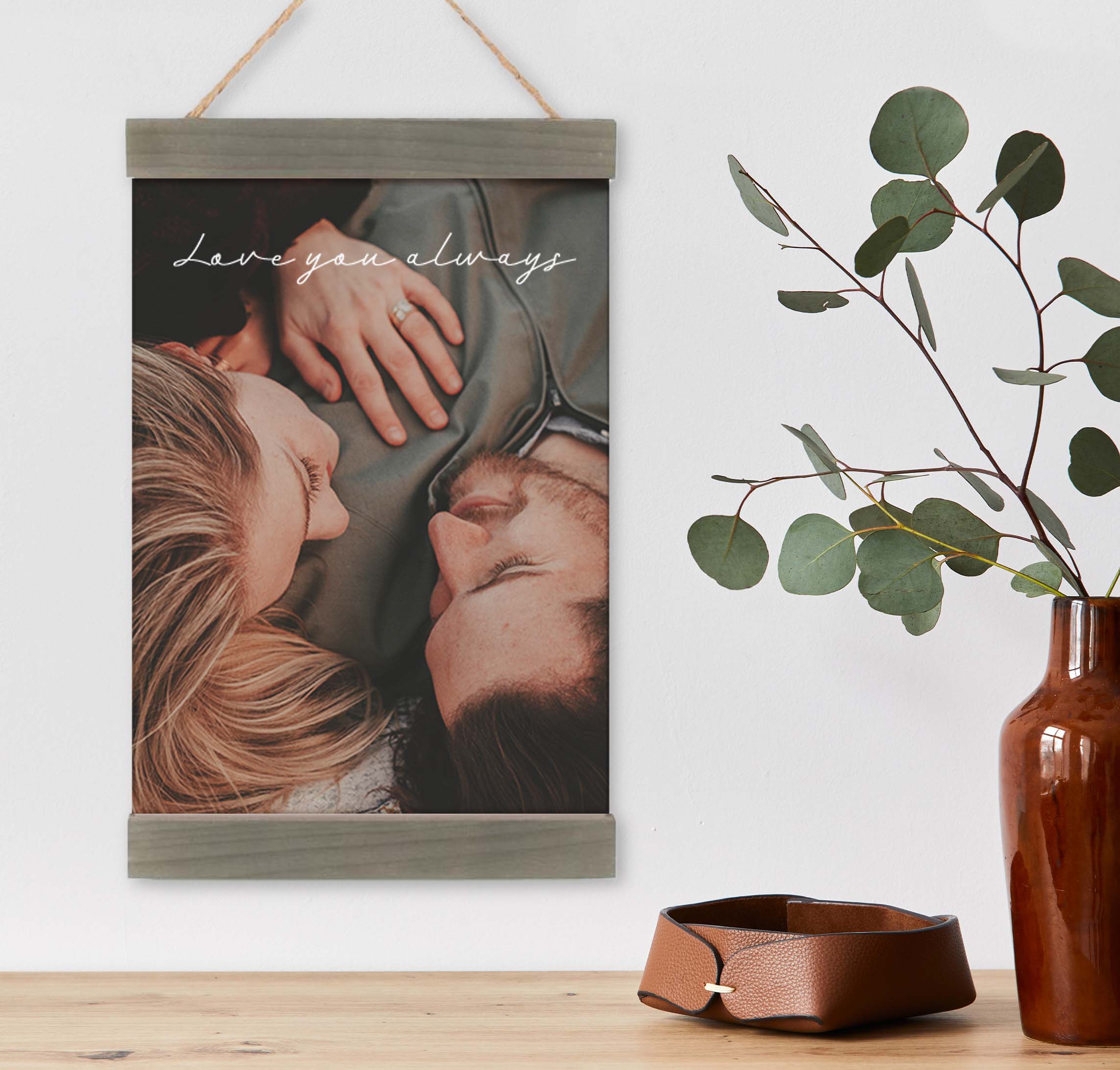 photo of a couple on a canvas wall hanging hung near a table with decor items on it