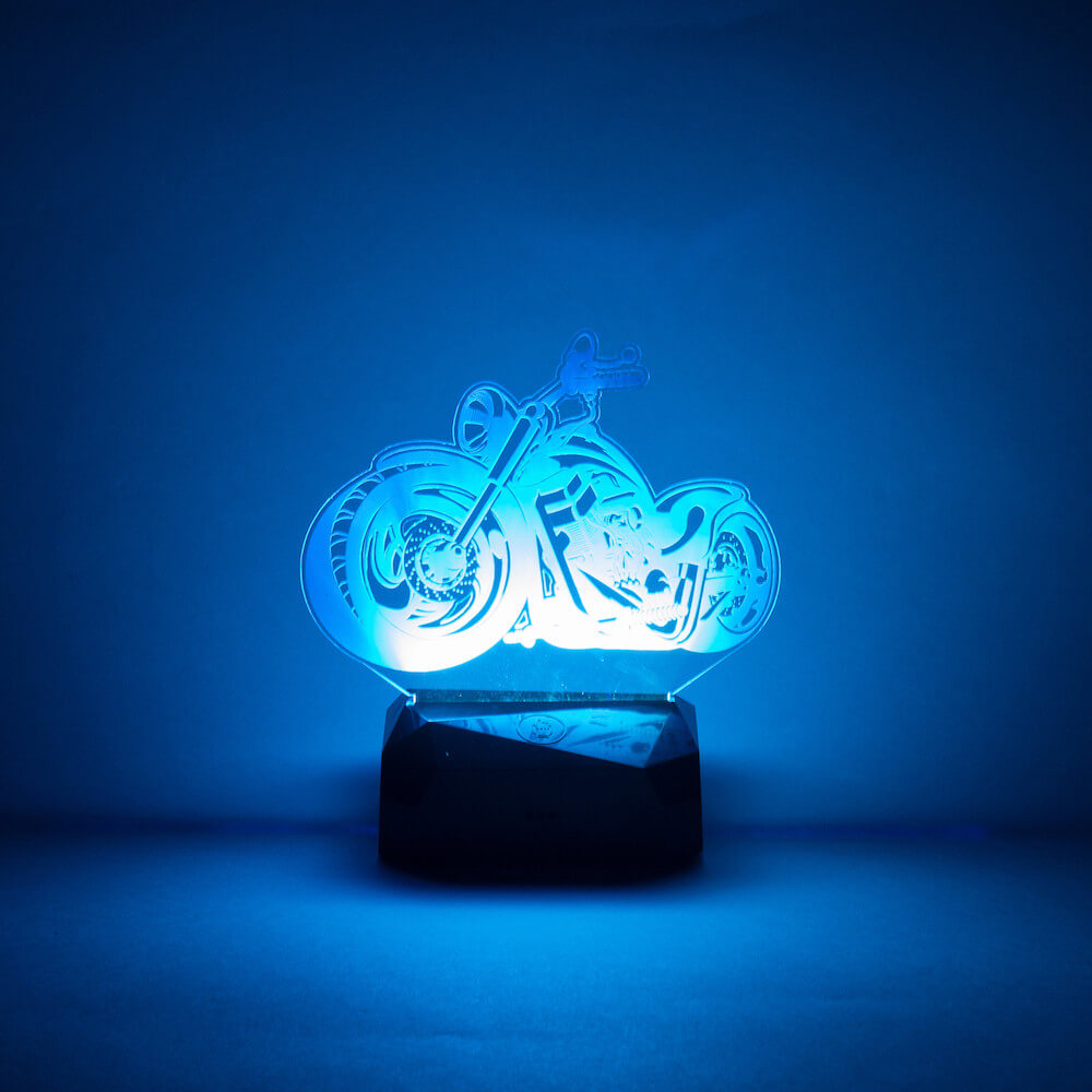 acrylic design of a motorcycle atop a rectangular light base that makes the design shine blue