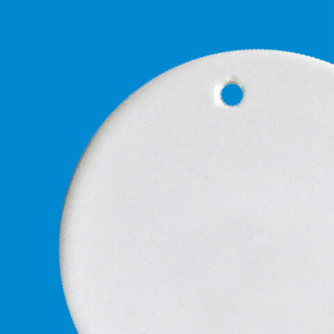 partial view of a white porcelain circle with a hole in the top for an ornament hanger